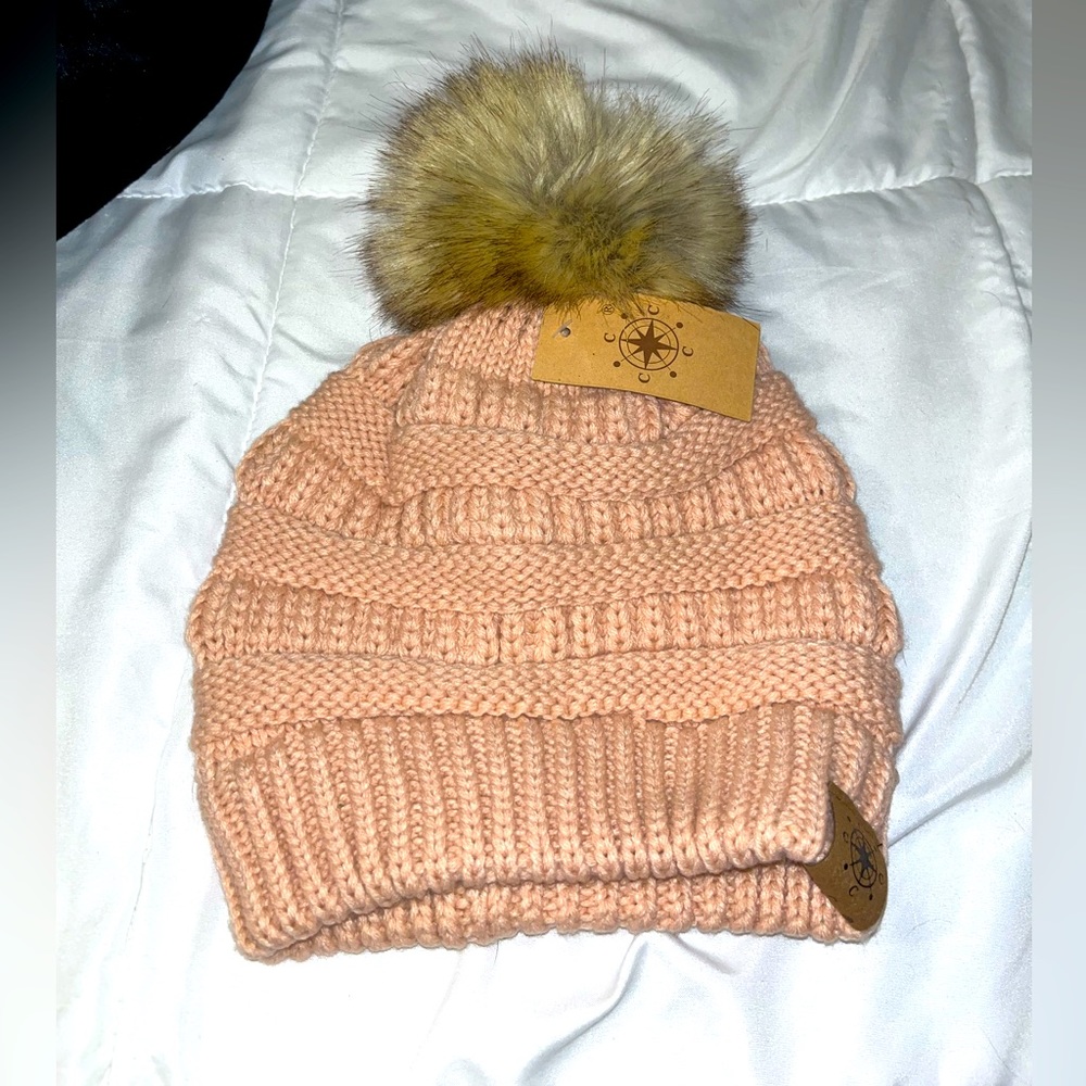 Knit pink beanie with puff ball.
